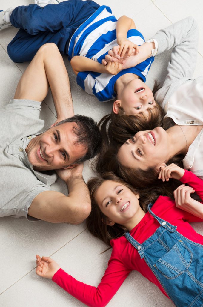 Family Laying Down With Heads Together