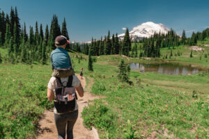 Mother carrying son on her shoulders on the trail